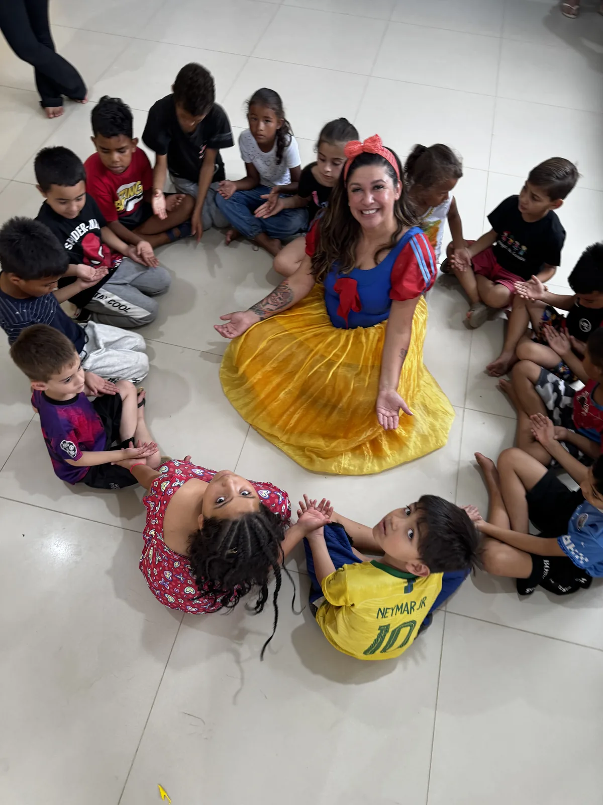 Tia Edi em roda com as crianças atendidas pelo projeto.